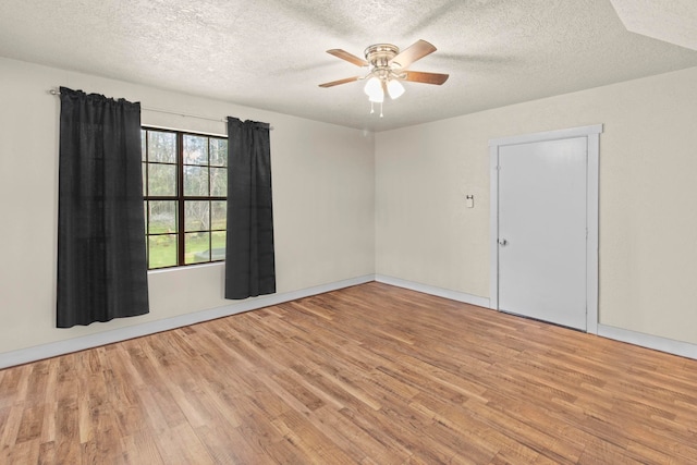 empty room featuring light wood-style floors, ceiling fan, and a textured ceiling