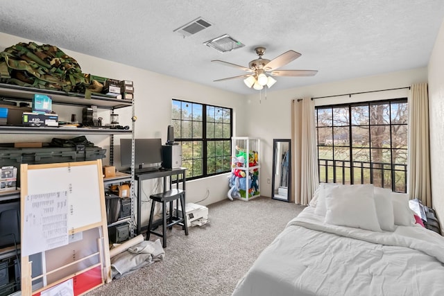 carpeted bedroom with visible vents, a textured ceiling, and ceiling fan