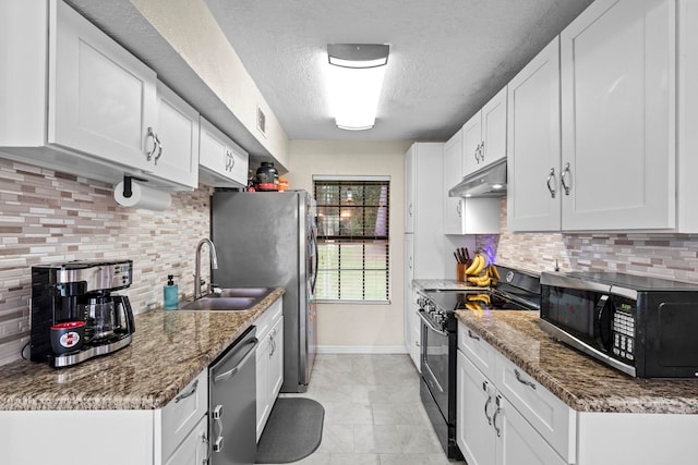 kitchen with a sink, black appliances, white cabinets, under cabinet range hood, and a textured ceiling