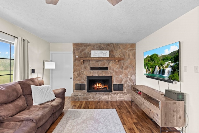 living area featuring a textured ceiling, wood finished floors, and a fireplace