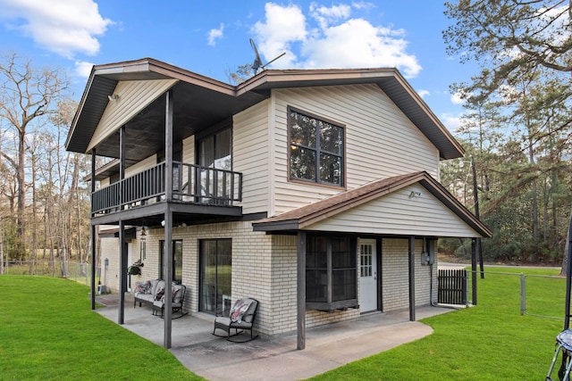 back of property featuring a patio area, a balcony, a lawn, and fence