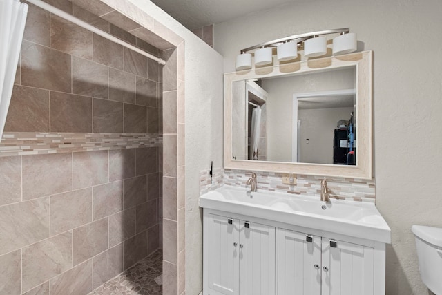 full bath featuring tiled shower, tasteful backsplash, toilet, and vanity