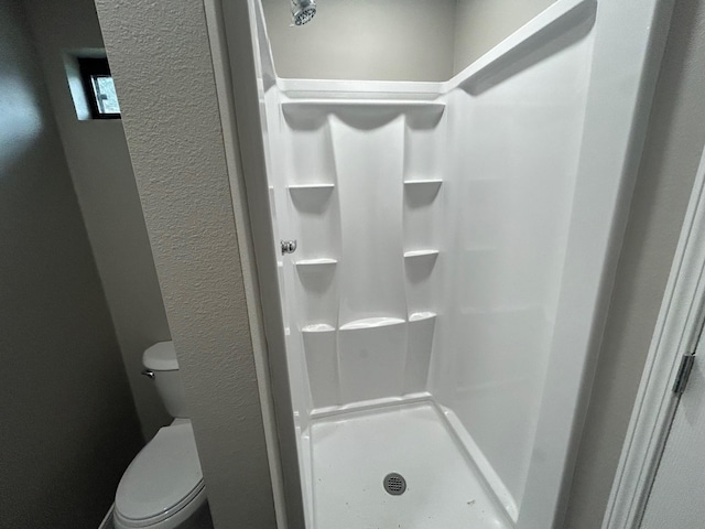 bathroom featuring a shower and toilet