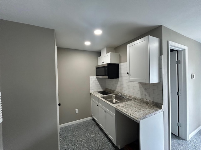 kitchen featuring decorative backsplash, sink, and white cabinets