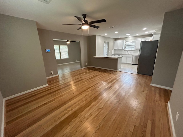 unfurnished living room with light hardwood / wood-style floors, ceiling fan, and sink