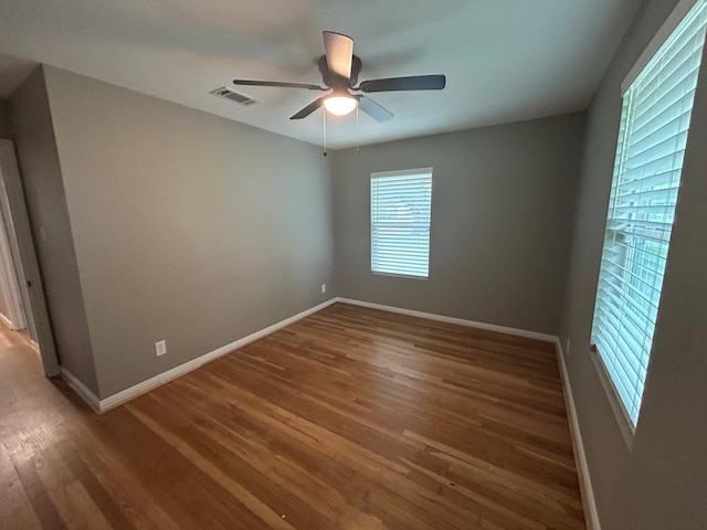 spare room with dark hardwood / wood-style flooring and ceiling fan