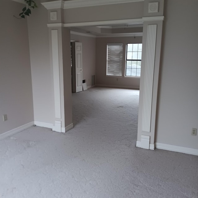 carpeted spare room featuring crown molding, visible vents, and baseboards