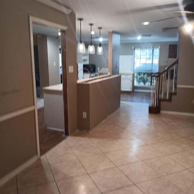 kitchen with a ceiling fan, baseboards, and pendant lighting