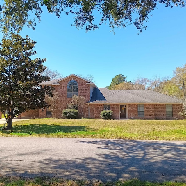 traditional-style house with brick siding and a front lawn