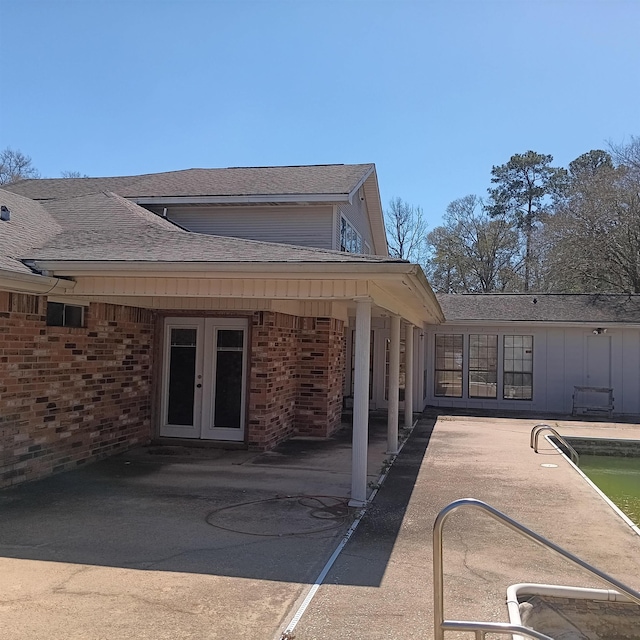 rear view of house featuring a patio, french doors, and brick siding