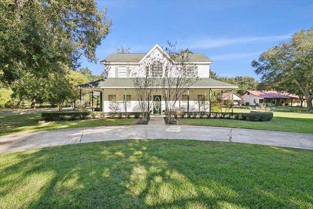 farmhouse inspired home with a front lawn and covered porch