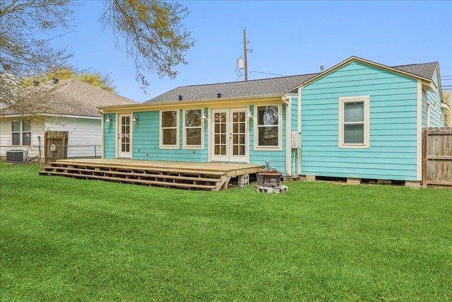 back of property with central AC unit, french doors, a deck, and roof with shingles