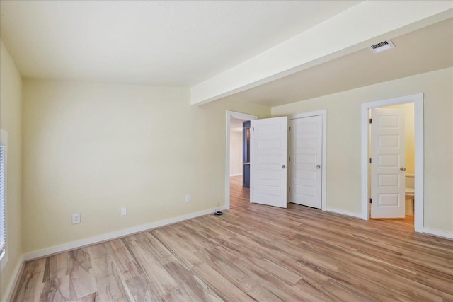 unfurnished bedroom with light wood-style flooring and baseboards