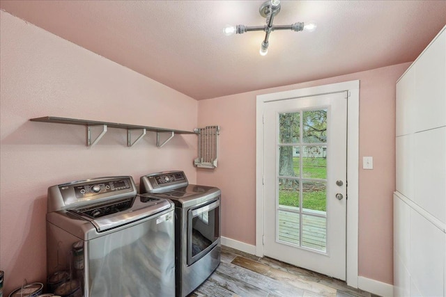 washroom with washer and dryer, light wood finished floors, and baseboards