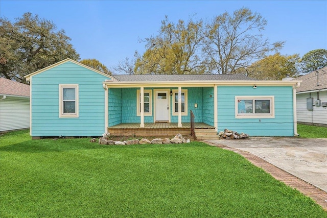 ranch-style house featuring covered porch and a front yard