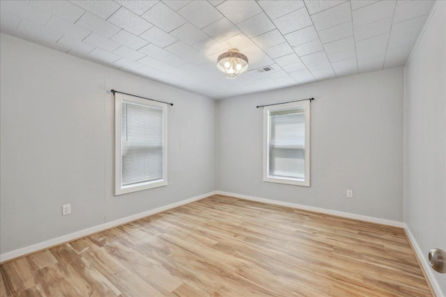 spare room featuring light wood finished floors and baseboards