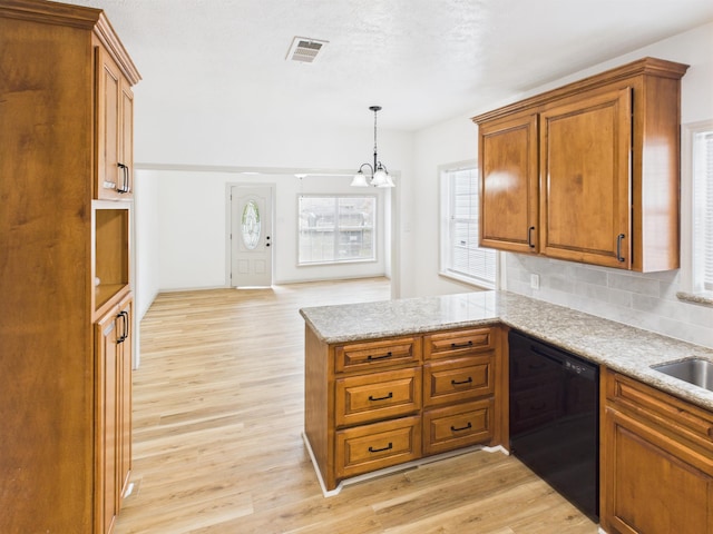 1832 19th St, Port Arthur, TX 77640 - kitchen featuring dishwasher, brown cabinets, light wood-style flooring, a chandelier, and a peninsula