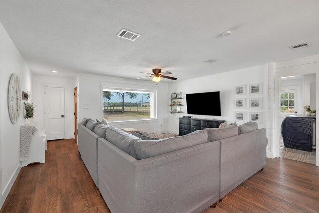 living room featuring dark hardwood / wood-style floors and ceiling fan