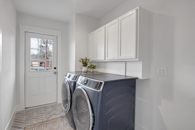 laundry room with separate washer and dryer and cabinets