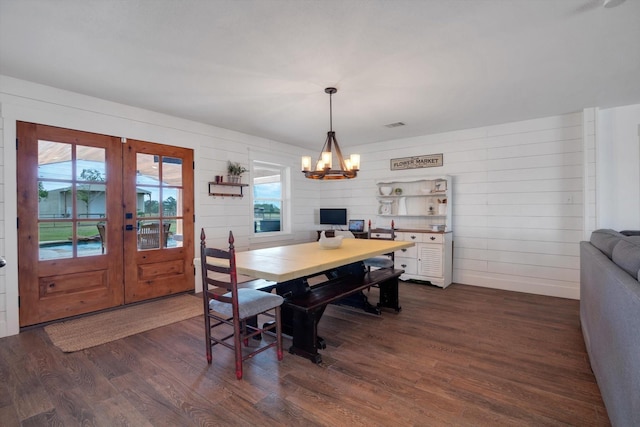 dining room with dark wood-type flooring, a chandelier, a healthy amount of sunlight, and french doors