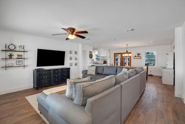 living room with dark hardwood / wood-style floors and ceiling fan with notable chandelier