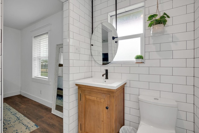 bathroom with vanity, hardwood / wood-style floors, tile walls, and toilet