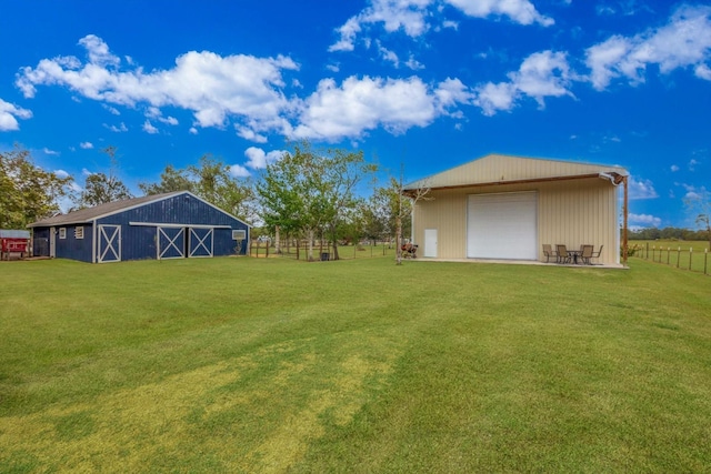 view of yard featuring a garage and an outdoor structure