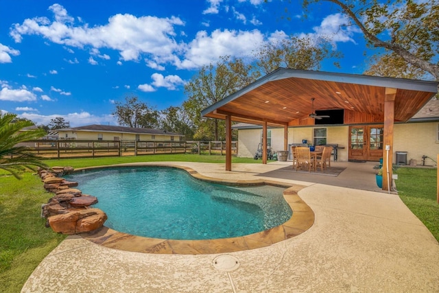 view of pool with a lawn, a patio area, ceiling fan, and french doors