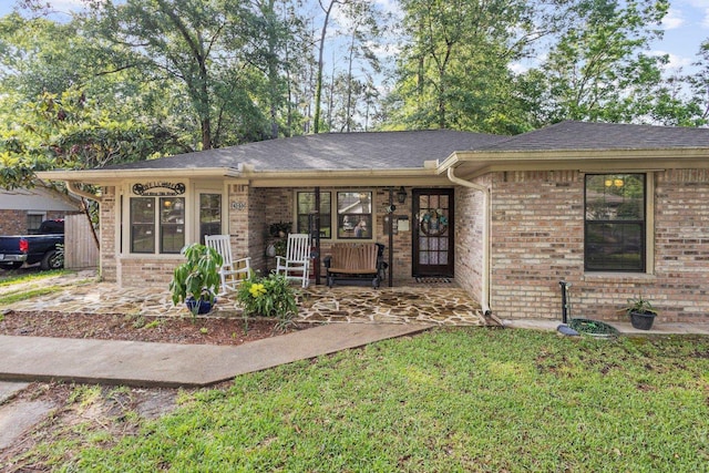 103 Read St, Silsbee, TX 77656 - view of front of property featuring roof with shingles, a porch, a front lawn, and brick siding