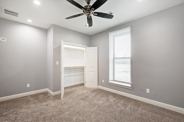 unfurnished bedroom featuring multiple windows, ceiling fan, a closet, and light colored carpet