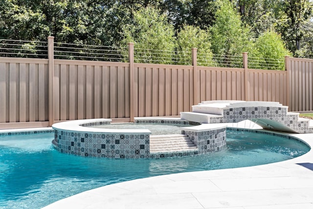 view of pool featuring pool water feature and a jacuzzi