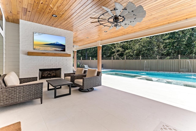 view of pool with an outdoor living space with a fireplace and a patio