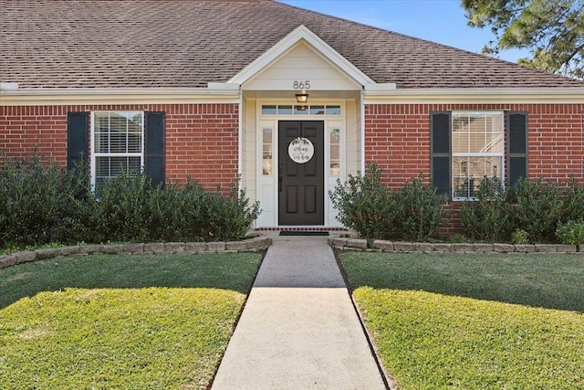 view of exterior entry with a yard