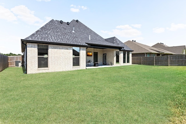 back of house featuring a yard, central AC, and a patio area