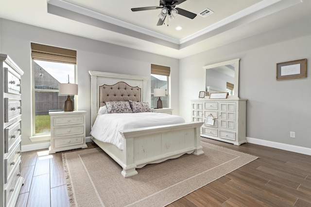 bedroom with a raised ceiling, ornamental molding, dark hardwood / wood-style floors, and ceiling fan