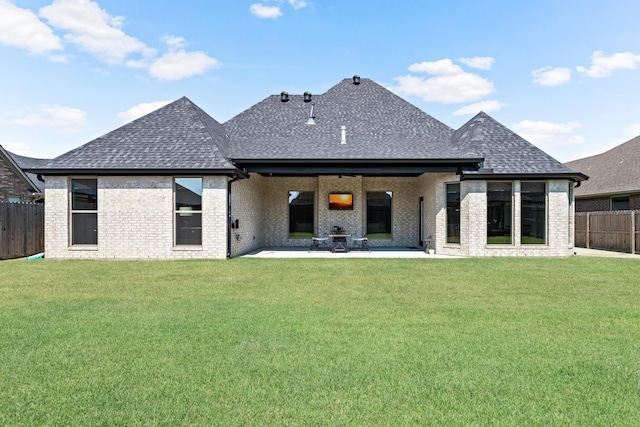 back of house with a patio and a lawn