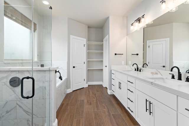 bathroom featuring vanity, wood-type flooring, and shower with separate bathtub