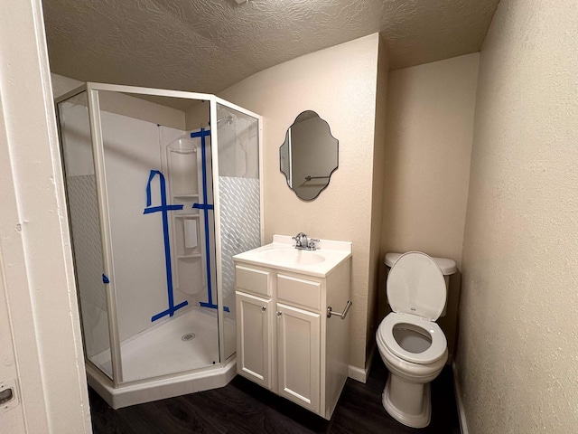 bathroom featuring vanity, a shower stall, and wood finished floors