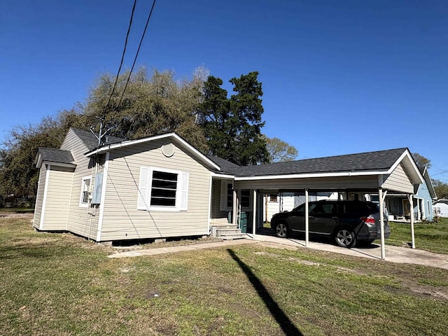 view of front of home with a carport, a front lawn, and a shingled roof