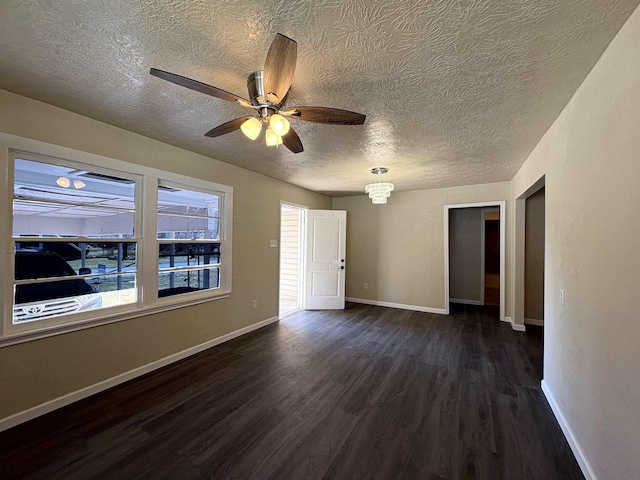 unfurnished room featuring baseboards, a textured ceiling, ceiling fan, and dark wood-style flooring