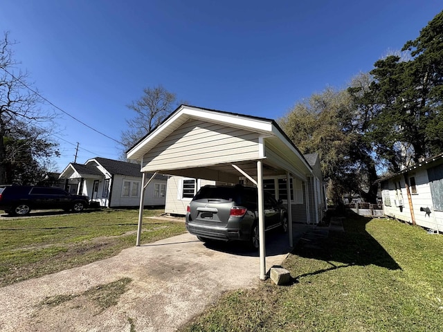 view of side of property with a carport, a yard, and concrete driveway