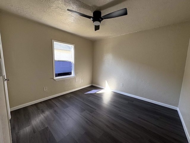 spare room featuring a textured ceiling, baseboards, ceiling fan, dark wood-style flooring, and a textured wall