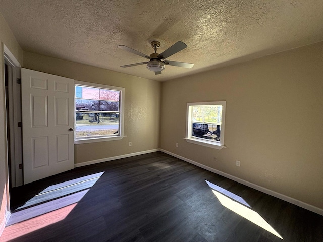 unfurnished bedroom with ceiling fan, baseboards, a textured ceiling, and dark wood finished floors