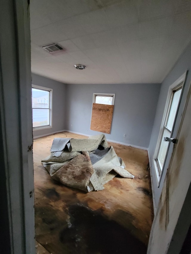 bedroom featuring visible vents, multiple windows, and baseboards