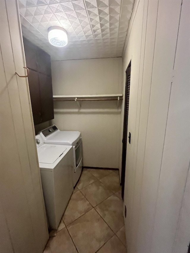 laundry room with washing machine and dryer and light tile patterned floors