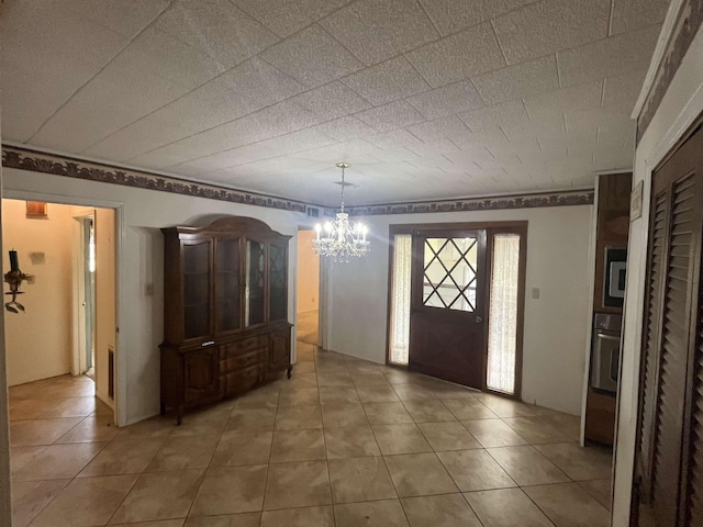 tiled entrance foyer featuring a chandelier