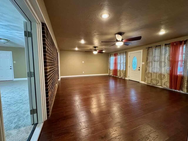 207 Lucky Dr, Silsbee, TX 77656 - unfurnished living room featuring a ceiling fan, baseboards, hardwood / wood-style floors, and a textured ceiling