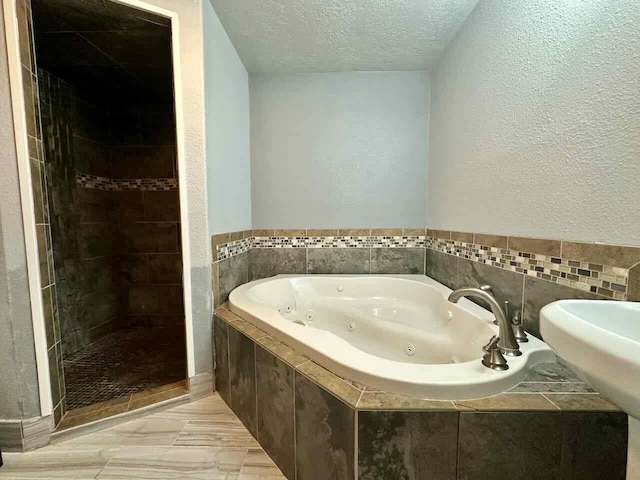 207 Lucky Dr, Silsbee, TX 77656 - full bathroom with a tub with jets, a tile shower, a textured ceiling, and a textured wall