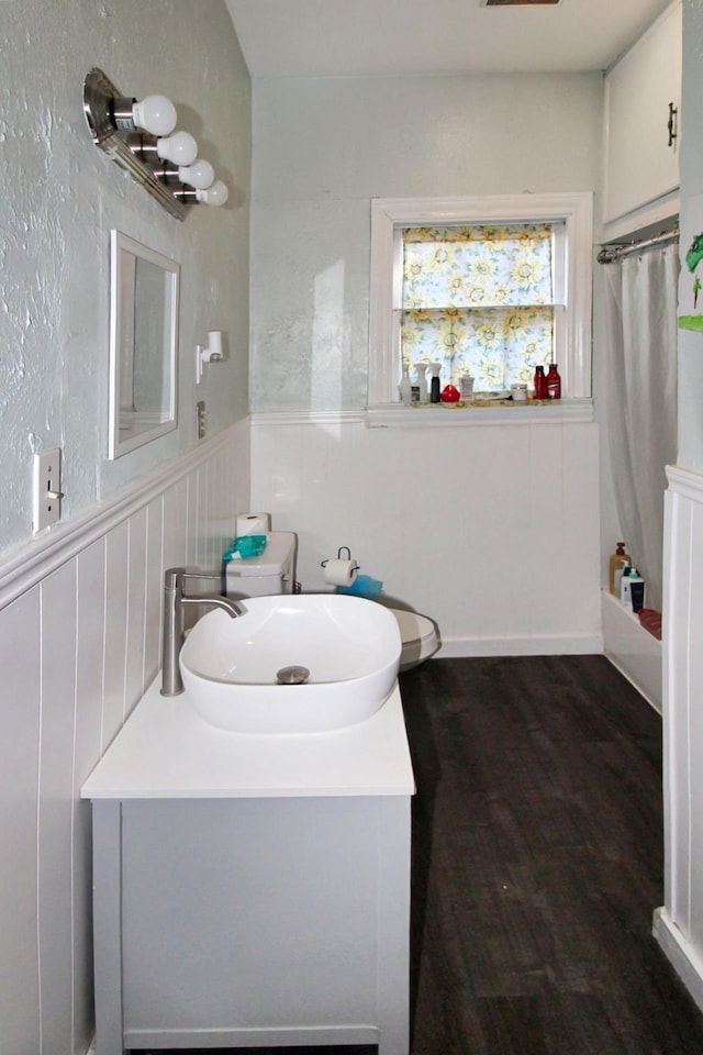 bathroom featuring hardwood / wood-style floors, vanity, and shower / tub combo