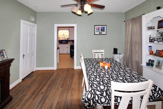 dining space featuring ceiling fan and dark wood-type flooring